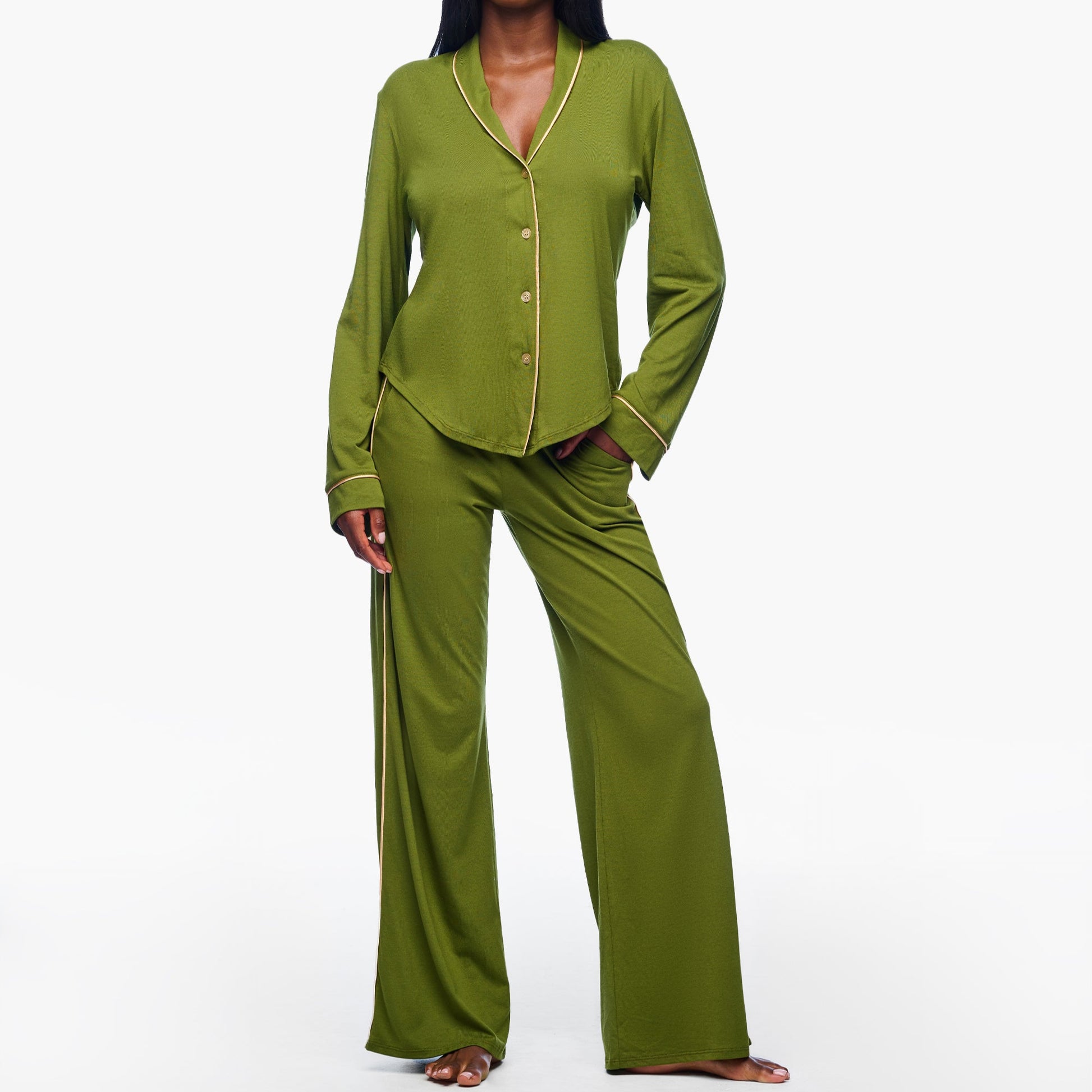 Woman wearing a green pajama set on a white background