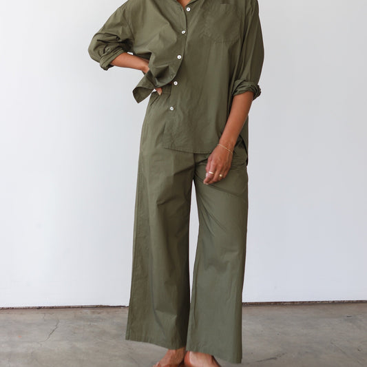 Woman wearing an olive green outfit against a white background