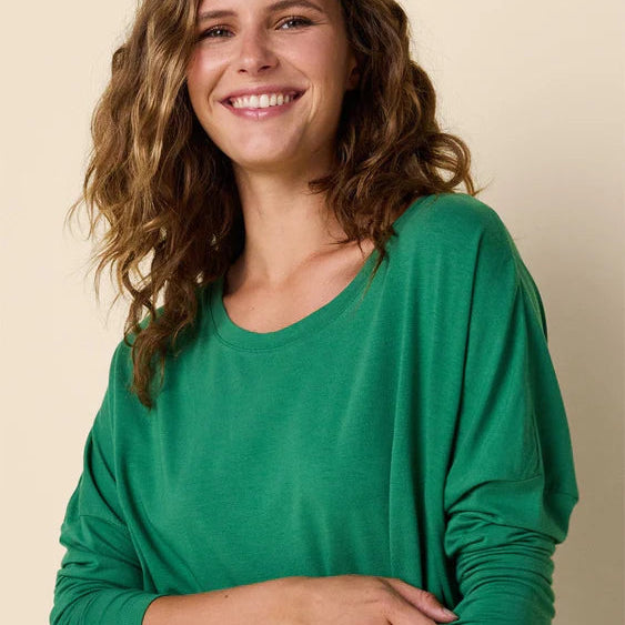 Woman wearing a green dress against a beige background