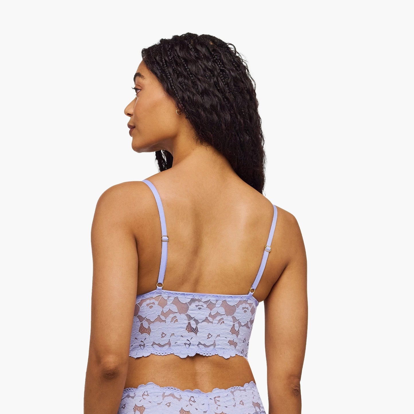Woman wearing a light blue lingerie set with a subtle pattern on a white background