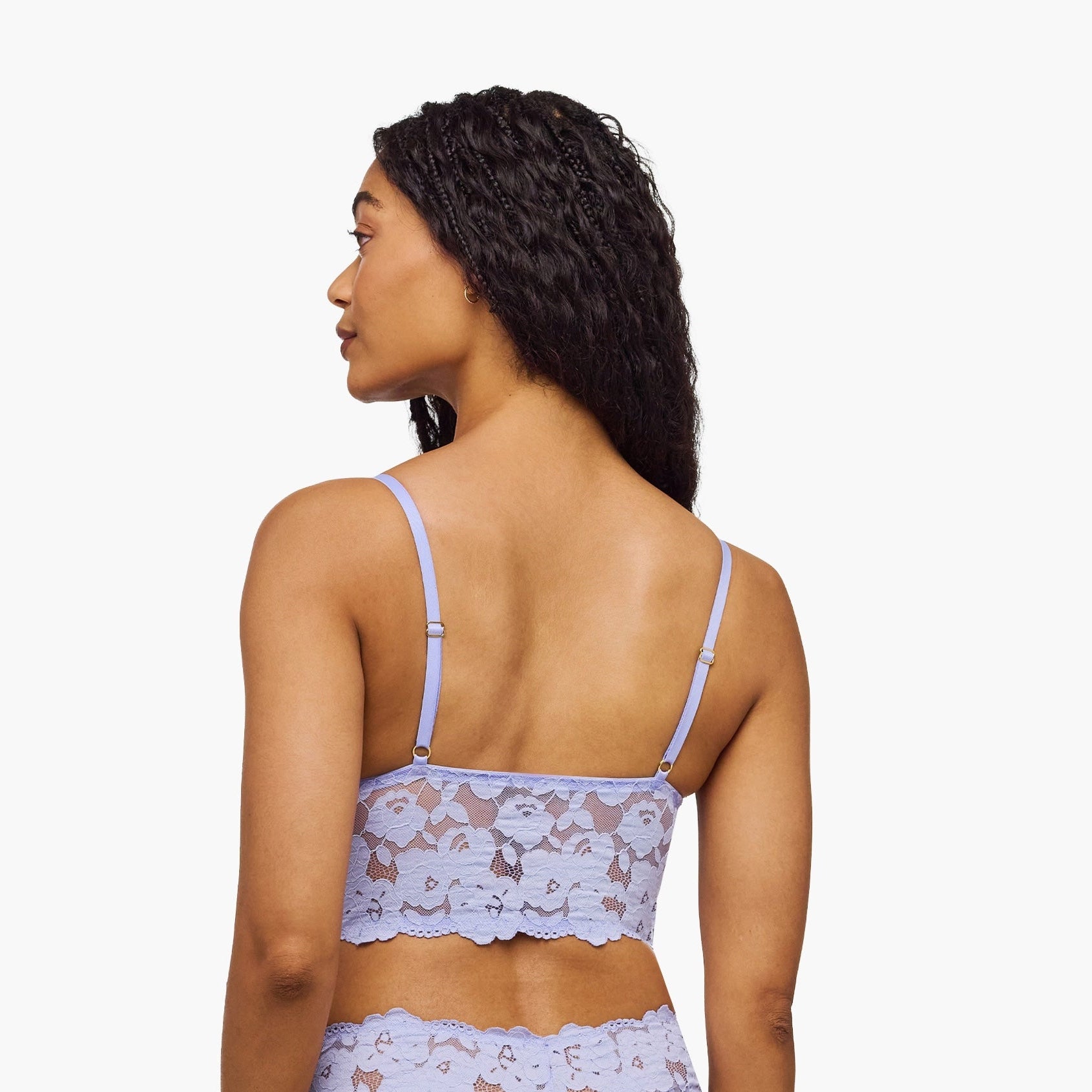 Woman wearing a light blue lingerie set with a subtle pattern on a white background