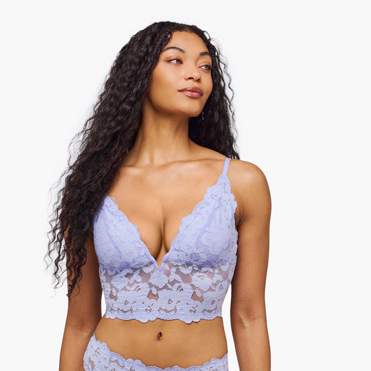 Woman wearing a light purple lace lingerie set on a white background