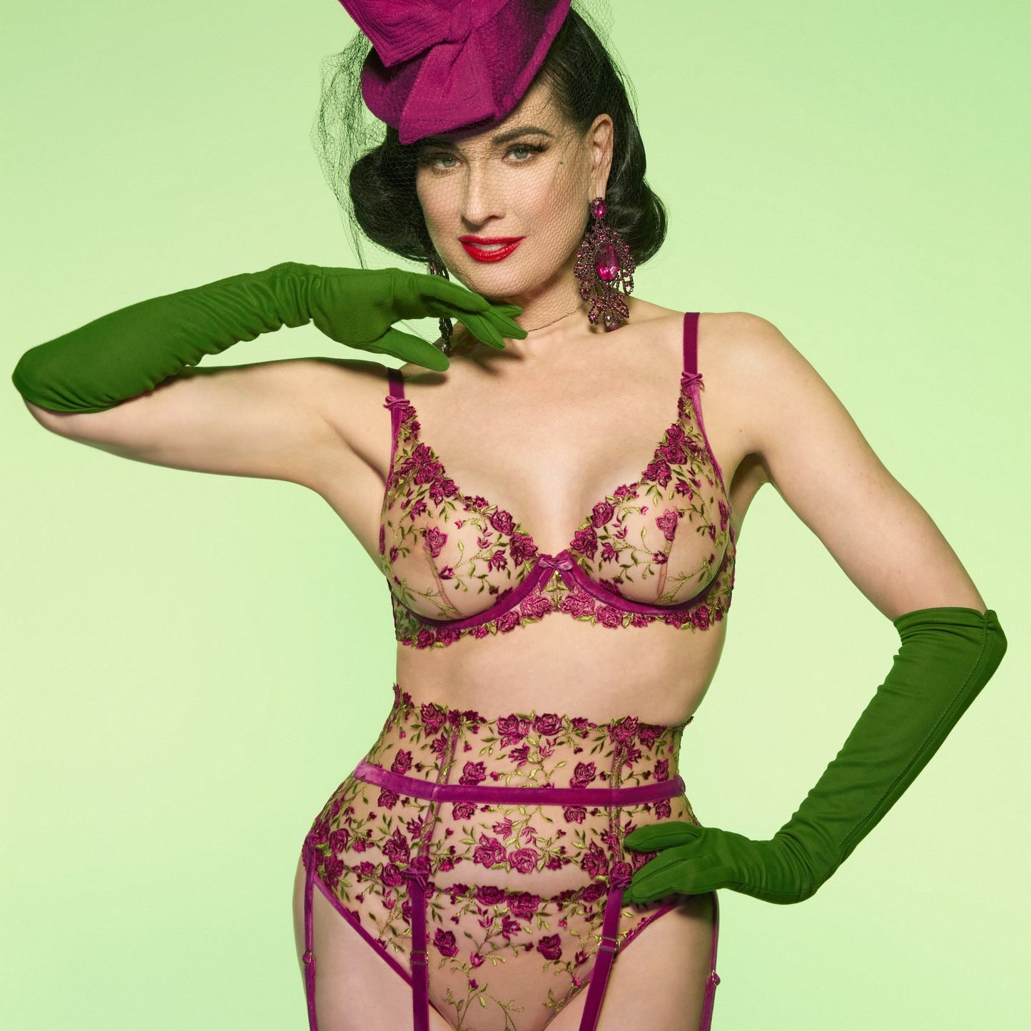 Woman in vintage lingerie and hat against a light green background