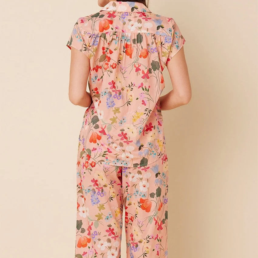 Woman wearing a floral pajama set on a beige background