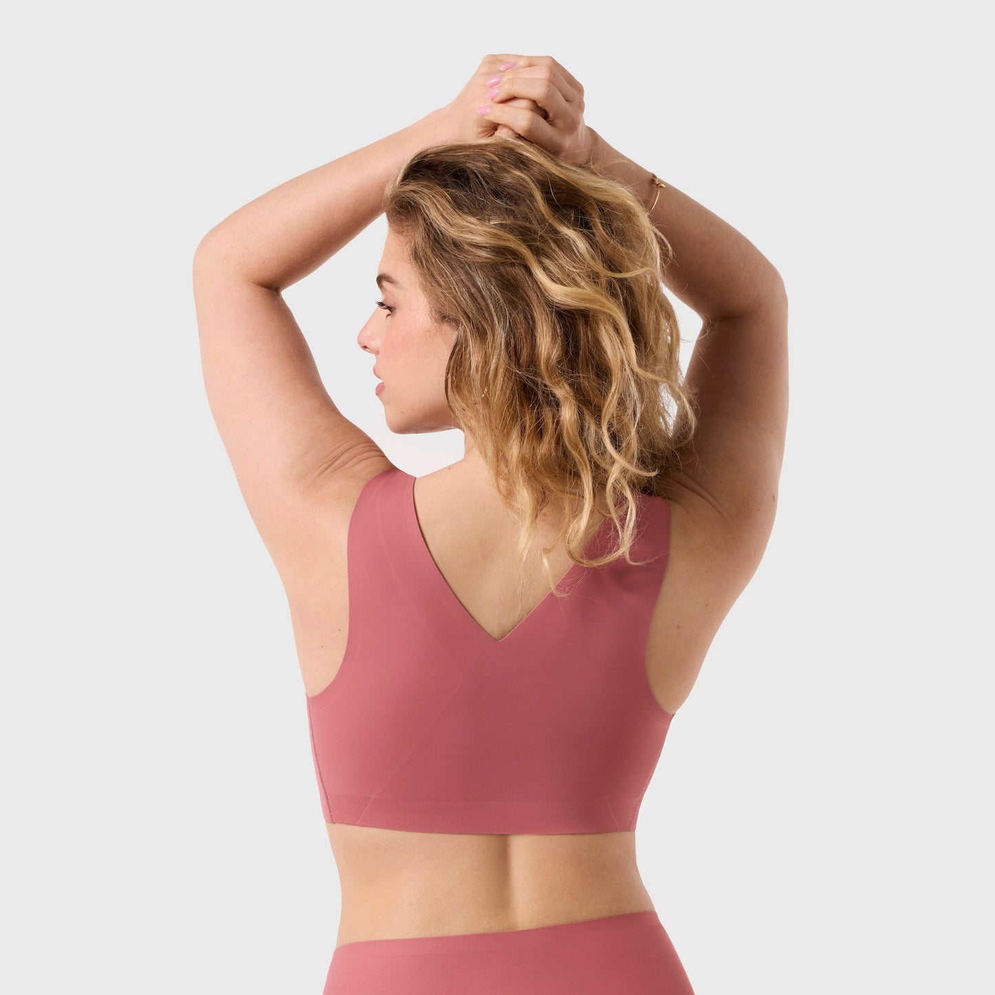 Woman wearing a pink swimsuit on a white background