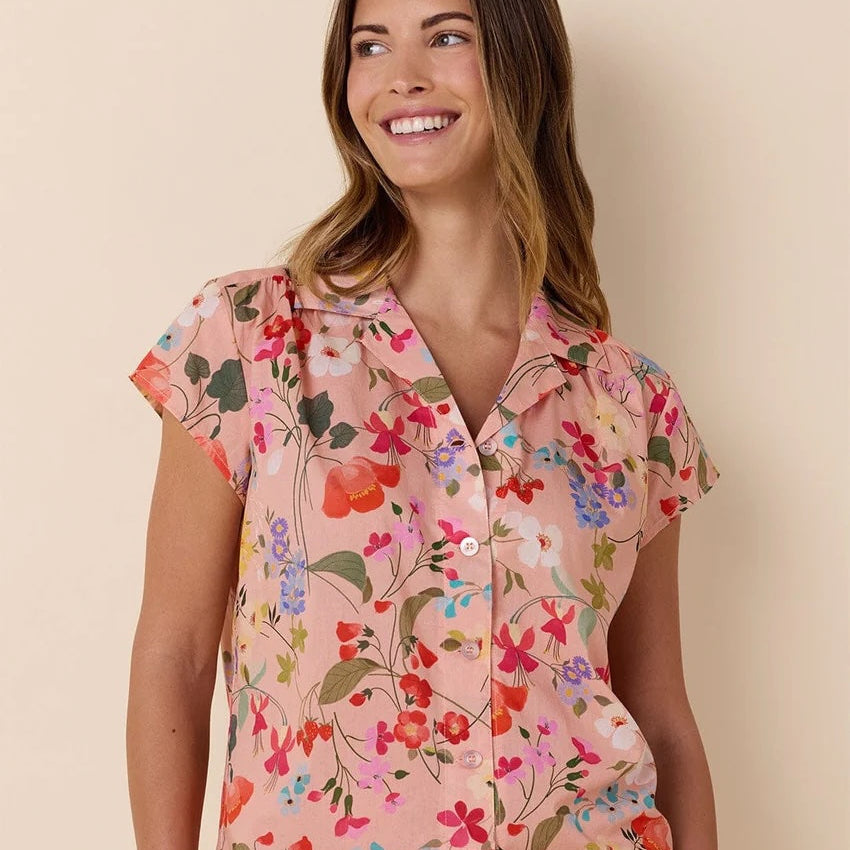 Woman wearing a floral pajama set against a beige background