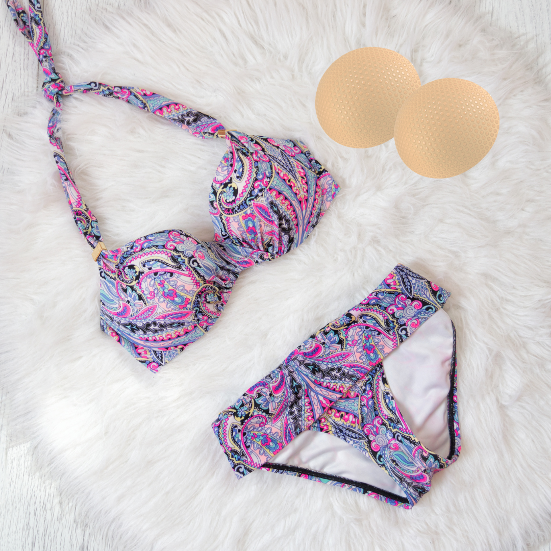 Patterned bikini set on a white fluffy surface with two beige balls.
